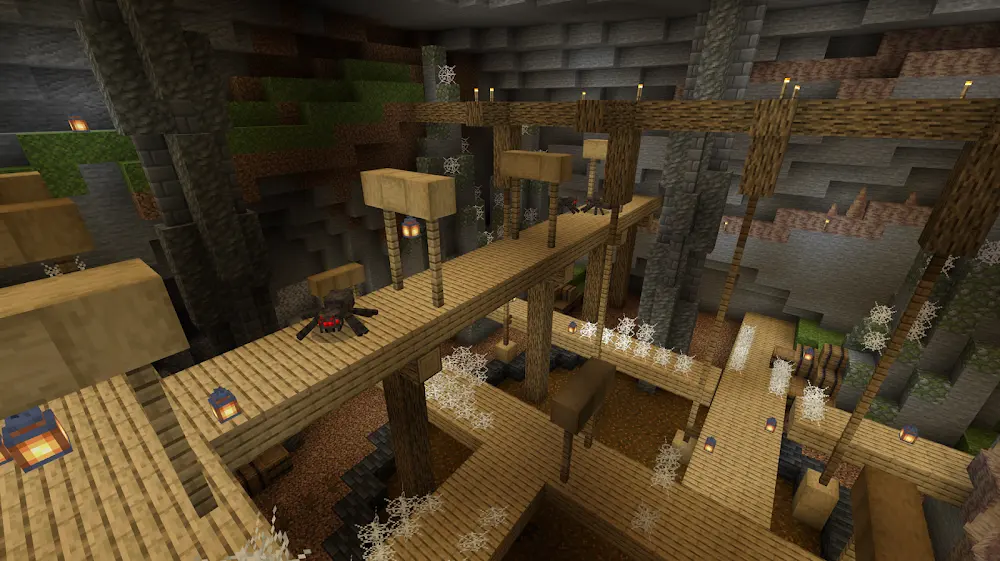 Schermata ufficiale di Minecraft: un'impalcatura di assi e travi di legno attraversa una caverna illuminata da lanterne, con ragnatele e binari sul fondo.